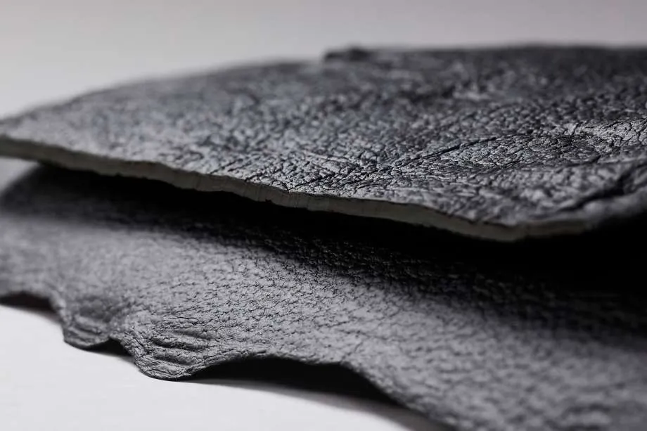 Macro view of a dark, textured sheet of mycelium material